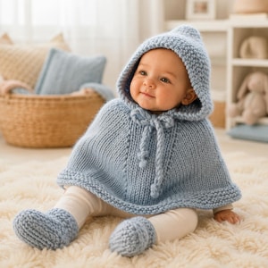 Può includere: Un poncho per neonati in maglia color azzurro con cappuccio e chiusura con laccetti abbinati sul collo, abbinato a scarpine in maglia color azzurro. Il set è realizzato in filato grosso con una visibile trama a coste e un bordo a legaccio.