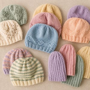 Könnte beinhalten: Eine Sammlung von zwölf gestrickten Mützen in verschiedenen Pastellfarben wie Salbeigrün, Creme, Gelb, Rosa, Blau, Lavendel und Pfirsich. Die Mützen weisen unterschiedliche Texturen auf, darunter Rippenmuster, rautenförmige Zopfmuster und Querstreifen.