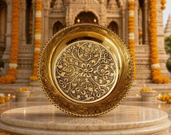 Può includere: Un piatto circolare in metallo color oro con bordo lucido e un'area centrale incavata decorata con un intricato motivo floreale in rilievo. Il piatto presenta un dettaglio a bordo perlato e una finitura metallica riflettente.