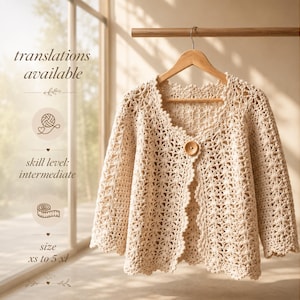 May include: A cream-colored crochet cardigan with a scalloped edge, long sleeves, and a single wooden button closure. The image includes text stating translations available, skill level: intermediate, and size xs to 5 xl.