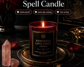 May include: A dark red glass candle with a black label reading Powerful Love Spell Candle, Attract Love - Deepen Connection, Ignite Passion. The candle sits on a gold plate with a lit wick, accompanied by a pink crystal point and a black matchbox.