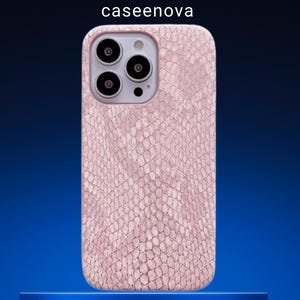 Könnte beinhalten: Eine hellrosa Smartphone-Hülle mit texturiertem Schlangenhautmuster. Die Hülle verfügt über einen Ausschnitt für ein Drei-Linsen-Kamerasystem. Der Text caseenova ist in Weiß über der Handyhülle aufgedruckt. Das Design bedeckt die Rückseite des Geräts.