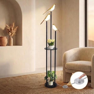 May include: A tall floor lamp featuring three black vertical poles and three gold-toned bird-shaped light fixtures at varying heights. The lamp includes two circular shelves for plants and a circular base, with a small circular floor foot switch.