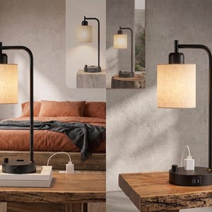 May include: A black metal table lamp with a cylindrical beige fabric shade and a curved arm. The circular base features a rotary switch, a power outlet, and two USB ports. The lamp emits a warm glow, providing functional lighting for a bedside table.