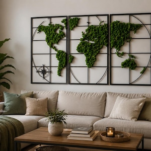 Puede incluir: Un conjunto de arte mural de tres paneles con un diseño de mapa mundial construido con marcos de metal negro rellenos de musgo verde preservado. El mapa incluye un detalle de rosa de los vientos en el panel izquierdo y muestra los continentes.