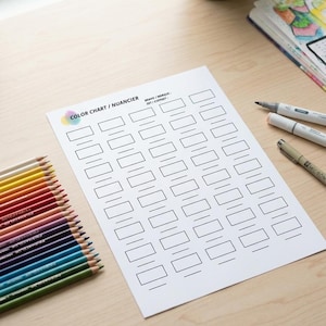 Peut inclure: Une feuille de papier blanche intitulée COLOR CHART / NUANCIER et BRAND / MARQUE / SET / COFFRET, présentant une grille de rectangles vides pour tester des couleurs, accompagnée d'une rangée de crayons de couleur et de deux feutres.