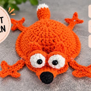 Könnte beinhalten: Eine Häkelanleitung für ein flaches, orangefarbenes Objekt in Fuchsform mit weiß-schwarzen Augen, einer schwarzen Nase und einer weiß gespitzten Schwanzspitze. Der Text lautet PDF CROCHET PATTERN, INSTANT DOWNLOAD, STEP-BY-STEP INSTRUCTIONS, PHOTOS INCLUDED und A funny gift idea!
