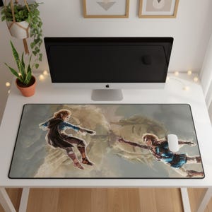May include: A rectangular desk mat featuring a printed illustration of two characters reaching toward each other in a style reminiscent of the Creation of Adam, set against a muted, cloudy background with a black border trim.