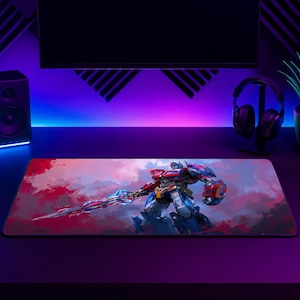 May include: A rectangular desk mat featuring a vibrant illustration of a red and blue robot character holding a glowing sword. The background consists of abstract red and purple brushstrokes, creating a dynamic scene on the smooth surface.