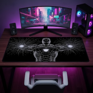 May include: A rectangular desk mat featuring a black and white graphic of a robotic armored figure with glowing white circular energy blasts emitting from both palms and a glowing white chest piece, set against a dark, detailed background.