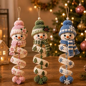 May include: Three crocheted snowman ornaments with spiral bodies hanging from jute loops. Each snowman wears a knit hat and scarf in pink, green, or blue. The spiral bodies are decorated with small flowers, pine trees, or snowflakes and beads.
