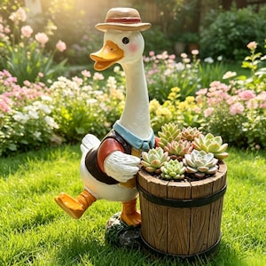 May include: A white goose figurine wearing a tan hat, a red vest, and a light blue collar, standing next to a brown, wood-textured barrel planter filled with several green and pink-tipped succulent plants, all set on a green grassy surface.