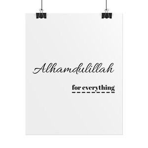 May include: A white rectangular wall poster featuring the black text Alhamdullilah in a cursive script, followed by the words for everything in a bold sans-serif font underlined with a dashed line, suspended by two black metal clips.