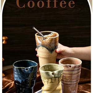 May include: Four ceramic tumblers with a unique tapered shape and a small hole near the rim for a straw. The cups feature varied finishes including dark blue, light yellow with a twisted texture, pinkish-brown stripes, and a tan glaze. Text reads Cooffee.