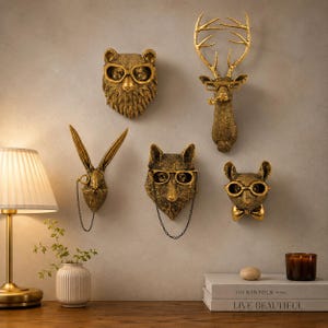 Könnte beinhalten: Ein Set aus fünf goldenen Tier-Wandskulpturen, bestehend aus einem Bären mit Brille, einem Hirsch mit Geweih und Brille, einem Hasen mit Monokel, einem Fuchs mit Brille und Kette sowie einer Maus mit Brille und Fliege, die an der Wand montiert sind.