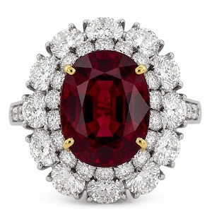 Può includere: Un anello con un rubino rosso intenso dal taglio ovale incastonato in griffe d'oro giallo, circondato da un doppio alone di diamanti bianchi rotondi a taglio brillante. Il tutto è montato su una fascia in metallo color argento lucido e simmetrico.