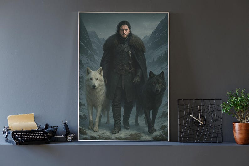 K&ouml;nnte beinhalten: Ein gerahmter vertikaler Wandkunstdruck, der eine dunkelhaarige Person in einem schweren schwarzen Mantel mit Pelzkragen in einem verschneiten Gebirgspass zeigt. Ein gro&szlig;er wei&szlig;er Wolf steht links und ein gro&szlig;er schwarzer Wolf rechts daneben.
