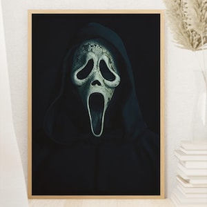 Könnte beinhalten: Ein gerahmter Wandkunstdruck mit einer kontrastreichen Illustration einer geisterhaften Figur, die einen dunklen Kapuzenumhang und eine blasse, längliche Maske mit hohlen schwarzen Augenhöhlen und offenem Mund vor schwarzem Hintergrund trägt.