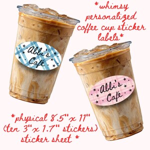May include: Two clear plastic cups filled with iced coffee, each featuring an oval sticker label. One sticker has a blue plaid pattern, the other a pink plaid pattern, both with black stars and the text Abbi's Café. Sheet size is 21.6 cm x 27.9 cm.