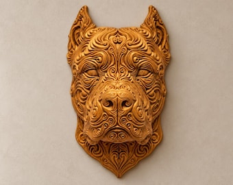 Può includere: Una scultura da parete a forma di testa di cane, realizzata in una calda tonalità marrone dorato. La superficie è ricoperta da intricati motivi in rilievo che seguono i contorni del muso, delle orecchie e della fronte.