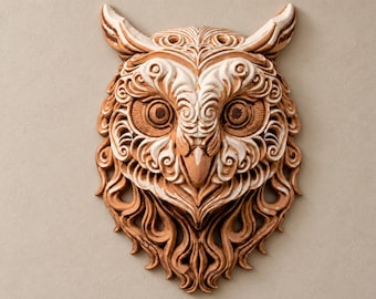 Può includere: Una scultura da parete a forma di gufo realizzata in materiale marrone chiaro e bianco. Il pezzo presenta intricati motivi a rilievo vorticosi sul viso, prominenti ciuffi auricolari, grandi occhi circolari e un becco affilato con texture fluide.