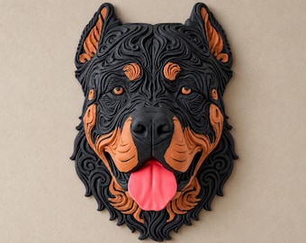 Può includere: Una scultura da parete raffigurante una testa di cane Rottweiler con motivi in rilievo a strati neri e marroni. Il cane ha occhi color ambra e una lingua rosa brillante che sporge, con intricate texture vorticose su tutto il design.