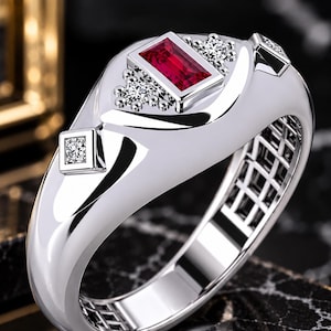 Puede incluir: Un anillo de tono plateado pulido con una piedra roja rectangular central en engaste de bisel, flanqueada por dos grupos de pequeñas piedras redondas transparentes y dos piedras cuadradas transparentes en la banda ancha.