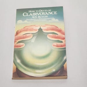 May include: A book titled "How to Develop Clairvoyance" by W.E. Butler. The cover art shows a green orb with hands reaching towards it. The book's subtitle reads "Everybody's guide to supernormal sense perception."