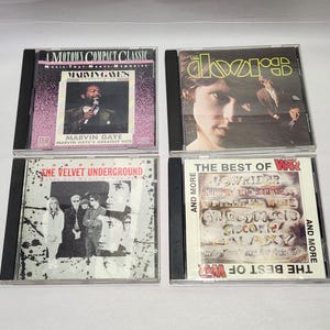May include: Four music CDs in clear plastic jewel cases. Top left: Marvin Gaye's Greatest Hits with a purple background. Top right: The Doors self-titled album. Bottom left: The Best of The Velvet Underground. Bottom right: The Best of War.