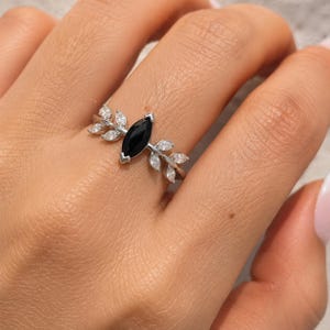 Anello con tormalina nera a taglio marquise, design a foglia in argento sterling e dettagli in moissanite.