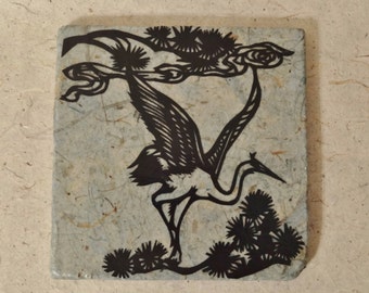 Trivet: Paper-covered stone with hand-cut crane design