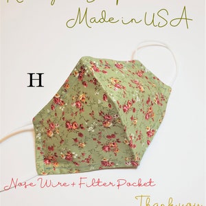May include: Green fabric face mask with a floral pattern. The mask has a nose wire and filter pocket. The text "Nose Wire + Filter Pocket" is written below the mask. The text "Ready to Ship Made in USA" is written at the top of the image. The letter "H" is written in the top left corner of the image. The text "Thank you" is written in the bottom right corner of the image.