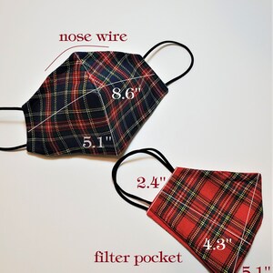 May include: Two plaid face masks with nose wires and filter pockets. The larger mask is black, red, and yellow plaid and measures 8.6 inches by 5.1 inches. The smaller mask is red, black, and yellow plaid and measures 4.3 inches by 5.1 inches.