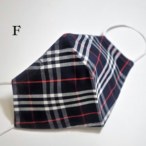 May include: A blue, white, and red plaid face mask with white elastic ear loops. The mask has a sewn seam down the center.