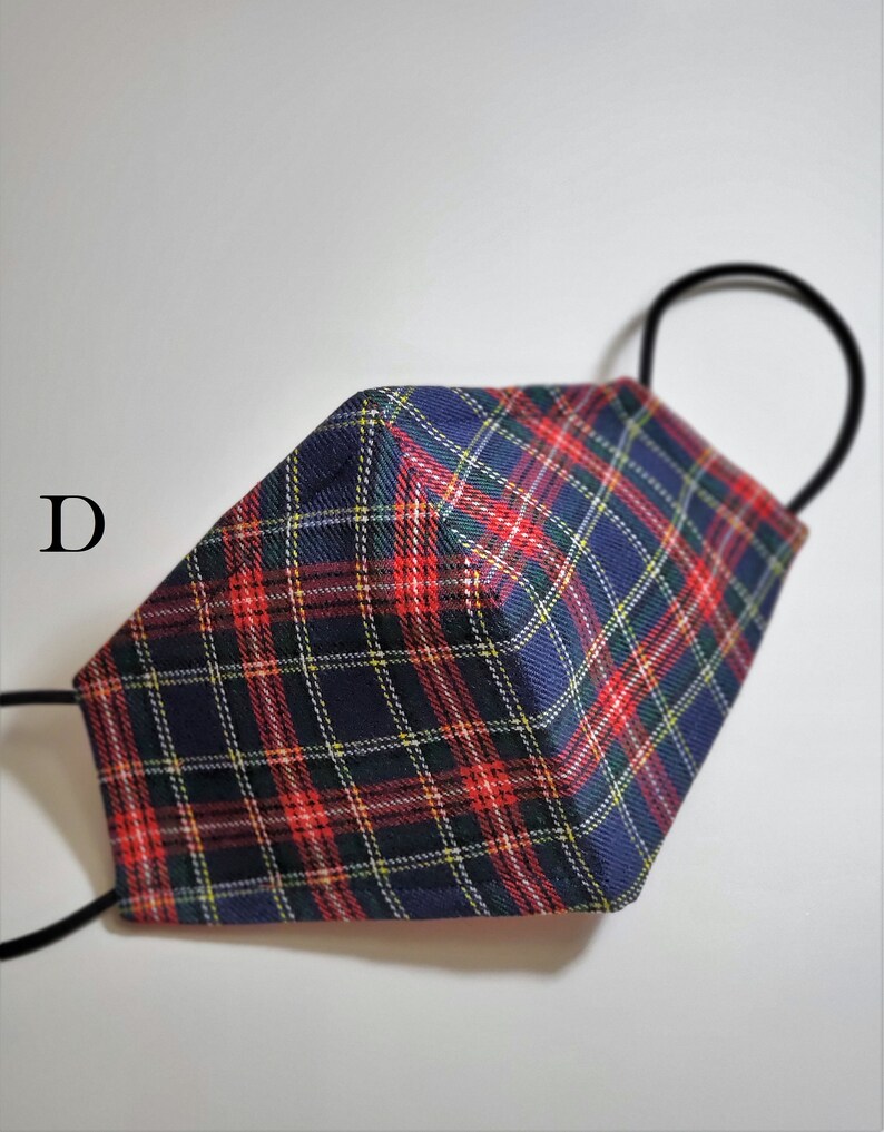 May include: A blue, red, and yellow plaid face mask with black elastic ear loops. The mask is folded in half and the ear loops are visible.