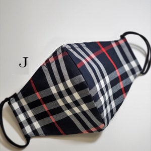May include: A black, white, and red plaid face mask with elastic ear loops. The mask has a 'J' printed on the side.