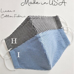 May include: Two face masks made from linen and cotton fabric. The masks are black and white gingham and blue and white gingham. The masks have nose wires and filter pockets. The text "Ready to Ship Made in USA" is at the top of the image. The text "Linen + Cotton Fabric" is below the masks. The text "H" and "I" are on the masks. The text "Nose Wire + Filter Pocket" is below the masks. The text "Thank you" is at the bottom of the image.
