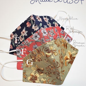 May include: Three fabric face masks with floral patterns. The masks are navy blue, red orange, and brown green. Each mask has a white nose wire and a filter pocket. The text "Ready to Ship Made in USA" is at the top of the image. The text "Nose Wire + Filter Pocket" is at the bottom of the image. The text "Thank you" is at the bottom of the image.