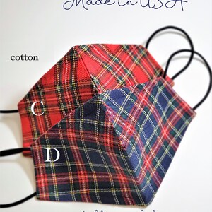 May include: Two red and blue plaid cotton face masks with nose wire and filter pocket. The masks are ready to ship and made in the USA. The text "C" and "D" are visible on the masks.