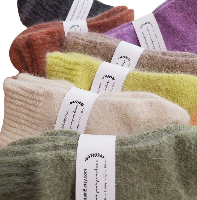 May include: A collection of fuzzy, ribbed knit socks in various colors including olive green, beige, lime green, tan, rust orange, purple, and dark gray. Each pair is secured with a white paper band featuring the text mountain8.etsy.com.