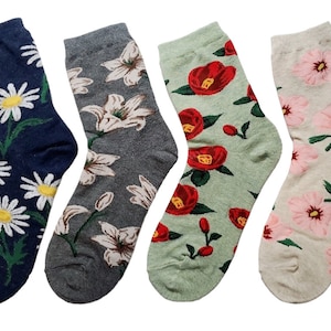 May include: Four pairs of colorful socks with floral patterns. The socks are in shades of blue, gray, green, and beige. Each sock features a different floral design, including daisies, lilies, camellias, and cherry blossoms.