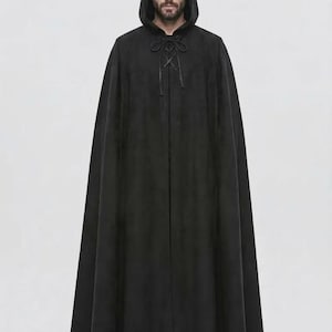 May include: A floor-length black hooded cloak featuring a front lace-up closure with thin black cords. The garment is made of a solid black fabric that drapes down to the ankles, providing full coverage with a structured hood and long sleeves.