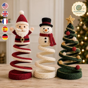 May include: Three crocheted holiday figures on spiral bases: a Santa Claus in red and white, a snowman with a black top hat and red scarf, and a green Christmas tree topped with a yellow star, decorated with small red and white spheres.