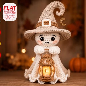 Op de afbeelding: Een gehaakt spookfiguurtje met een beige puntmuts met een bruine band en gesp. Het spookje heeft zwarte ogen, roze wangen en houdt een bruine gehaakte lantaarn vast met een halve maan en sterrenpatroon met een gloeiend licht erin.