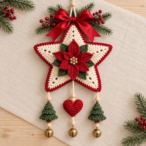 May include: A crocheted star ornament featuring a central red poinsettia with green leaves, topped with a red satin bow and pine sprigs. Three hanging cords feature wooden beads, two green crocheted trees, a red heart, and three brass bells.