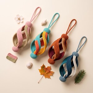 Pode incluir: Quatro ornamentos suspensos feitos de fio de croch&ecirc; com um design de gaiola em espiral. Cada ornamento possui um la&ccedil;o no topo e uma base esf&eacute;rica, exibindo combina&ccedil;&otilde;es de cores rosa e bege, azul-petr&oacute;leo e amarelo, laranja e marrom, e azul e branco.