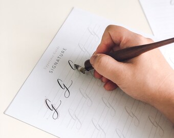 Puede incluir: Una persona practicando caligrafía con una pluma estilográfica y tinta en una hoja de papel blanca. El papel tiene líneas para practicar la letra "g" y las palabras "Uppercase Guide" y "SIGNATURE" están impresas en la parte superior de la página.