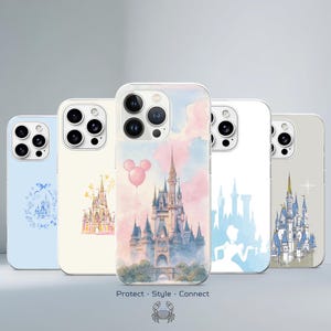 May include: Five smartphone cases featuring castle illustrations. The center case shows a detailed castle with a pink balloon against a watercolor sky. Other cases display blue and gold castle motifs, including a silhouette and a floral wreath design.