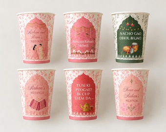 Puede incluir: Seis vasos de papel con patrones florales y diseños de arco. Cinco vasos son rosas con textos como Rahan and Xena's Mehndi, Rahan's Mehndi y Tusi Ki Pyogae. Un vaso es verde oscuro con el texto Nacho Gao Dhol Bajao y un gráfico de tambor dhol.