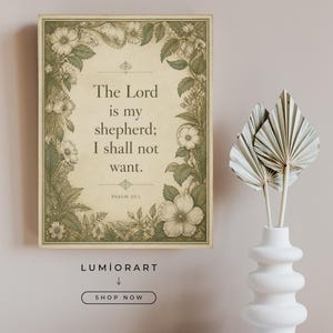 May include: A rectangular wall art print featuring a cream-colored background with a dark green botanical border of flowers and leaves. The text reads: The Lord is my shepherd; I shall not want. Psalm 23:1. The print is framed in a thin wood border.